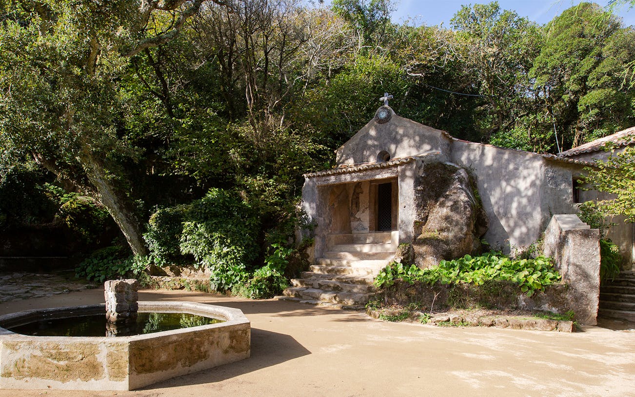 Convento dos Capuchos entrance surrounded by lush greenery in Sintra, Portugal.