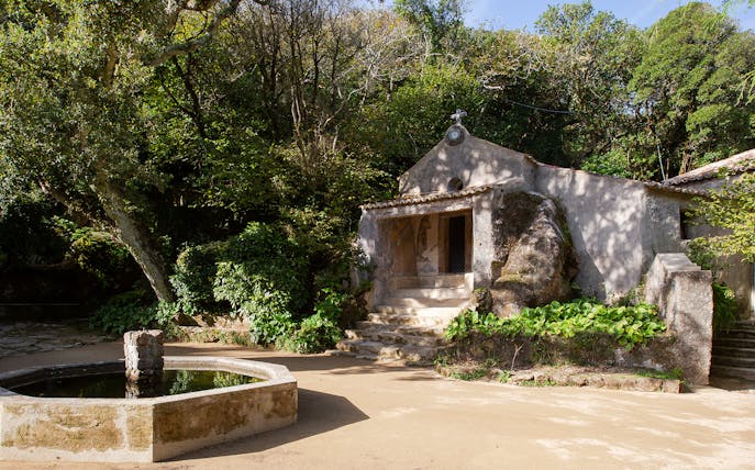 Convento dos Capuchos entrance surrounded by lush greenery in Sintra, Portugal.