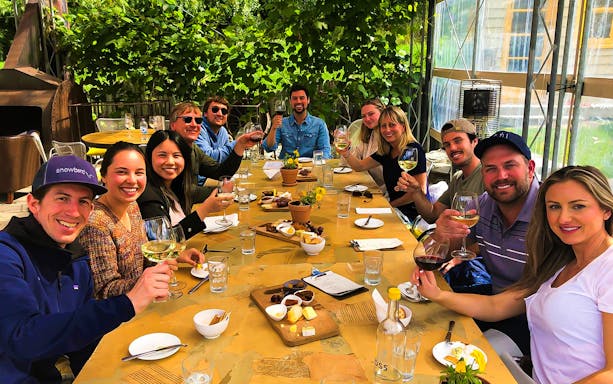 Group enjoying wine and cheese at a vineyard on a Queenstown gourmet tour.