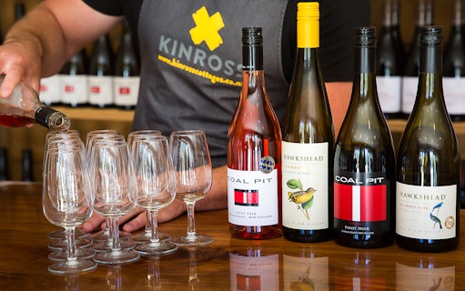 Pouring wine at a tasting with Coal Pit and Hawkshead bottles in Queenstown.