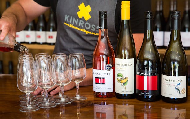 Pouring wine at a tasting with Coal Pit and Hawkshead bottles in Queenstown.