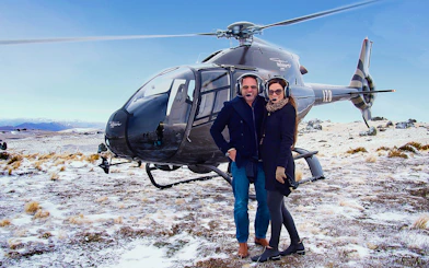 Helicopter landing on snowy terrain during Queenstown gourmet food and wine tour.