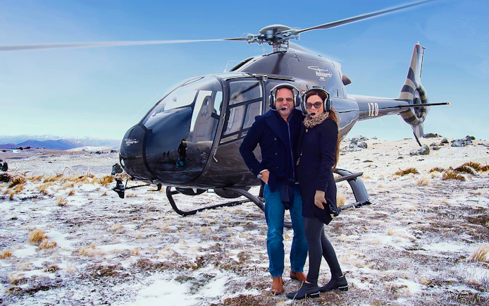 Helicopter landing on snowy terrain during Queenstown gourmet food and wine tour.