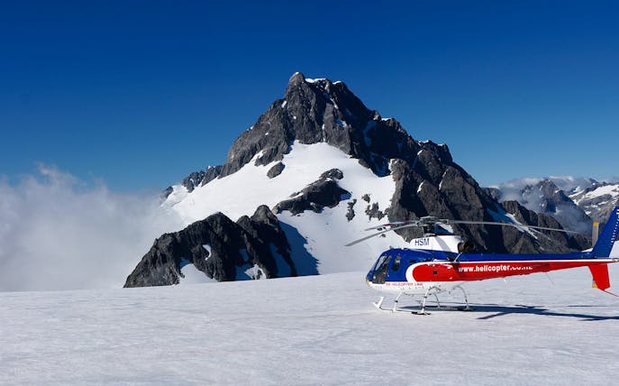 Helicopter on snowy alpine landing with mountain backdrop, Queenstown Panorama Tour.