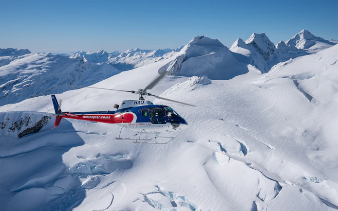Helicopter flying over snowy mountains during Queenstown Panorama Helicopter Tour.
