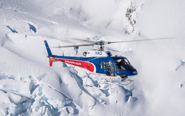 Helicopter flying over snowy alpine landscape during Queenstown Panorama Tour.