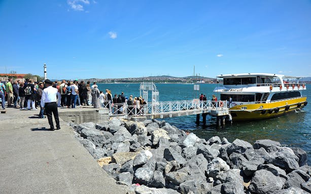 Tourists boarding a cruise boat at a dock on the Bosphorus in Istanbul.
