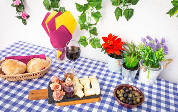 Portuguese snacks and wine on a checkered table during a Lisbon walking tour.