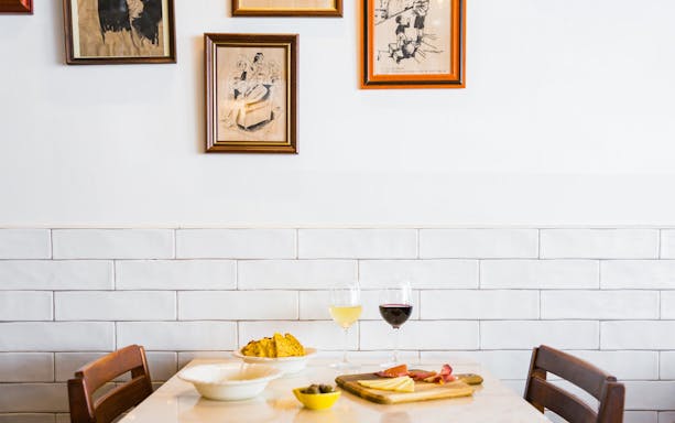 Lisbon cafe table with wine, cheese, and charcuterie during guided walking tour.