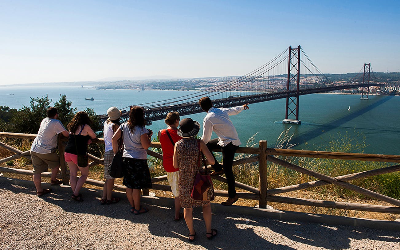 Group overlooking 25 de Abril Bridge on wine tour from Lisbon to Arrábida.