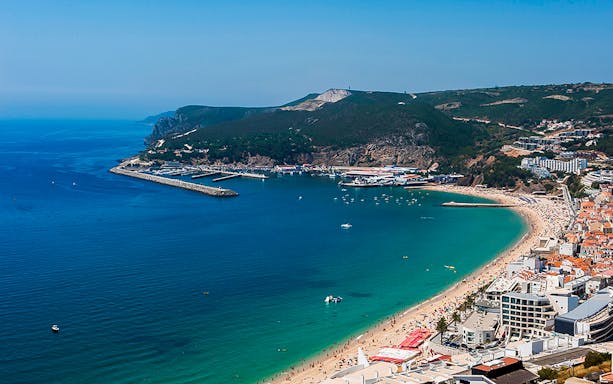 Arrábida coastline view with beach and marina, part of a small group wine tour from Lisbon.