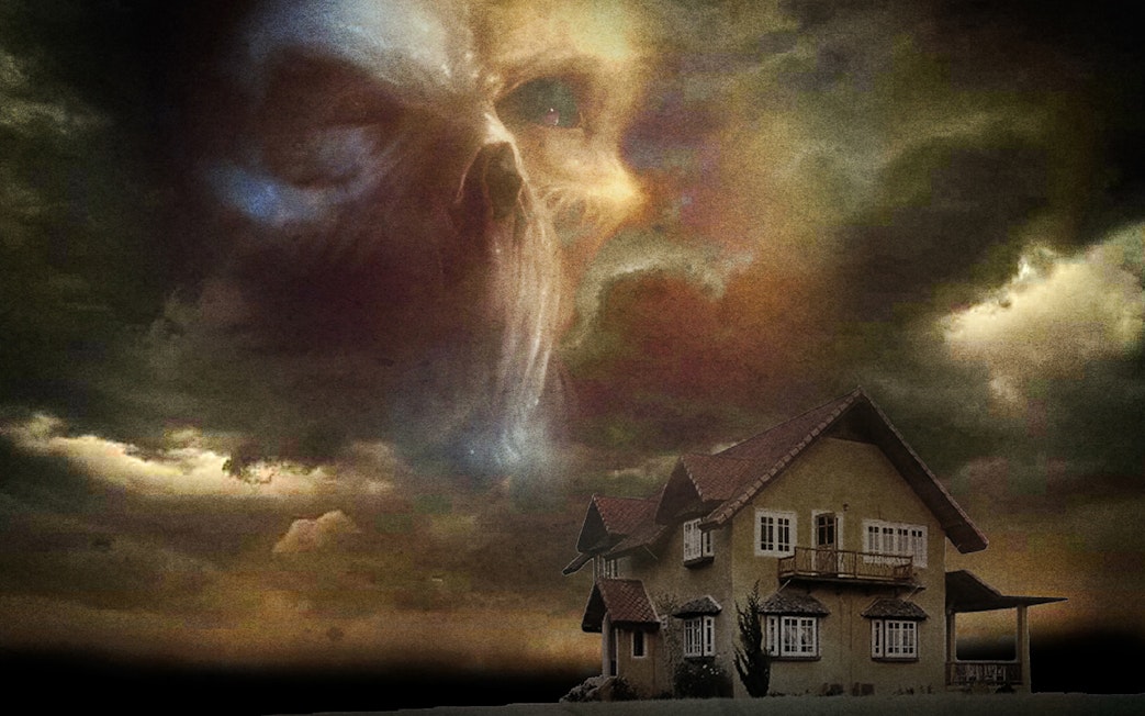 Haunted house under stormy sky with ghostly face, Trapped Escape Room, Singapore.