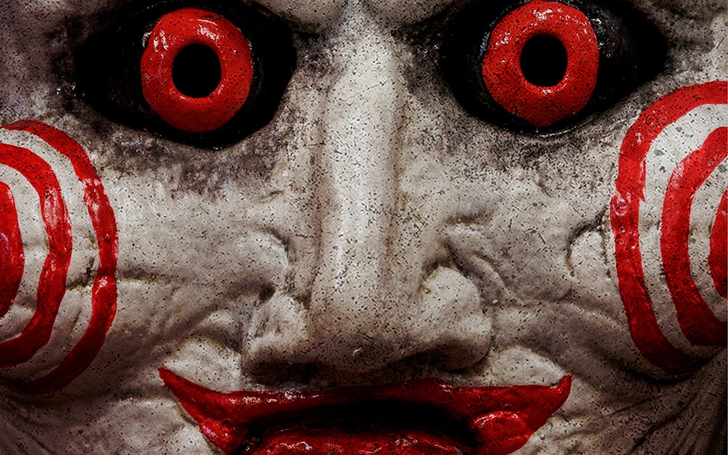 Creepy mask with red eyes and spiral cheeks at Trapped Escape Room, Singapore.