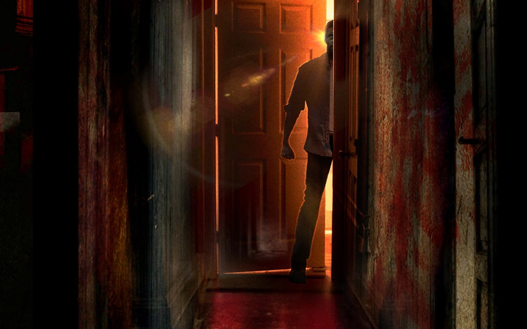 Person entering dimly lit escape room in Singapore with open door.