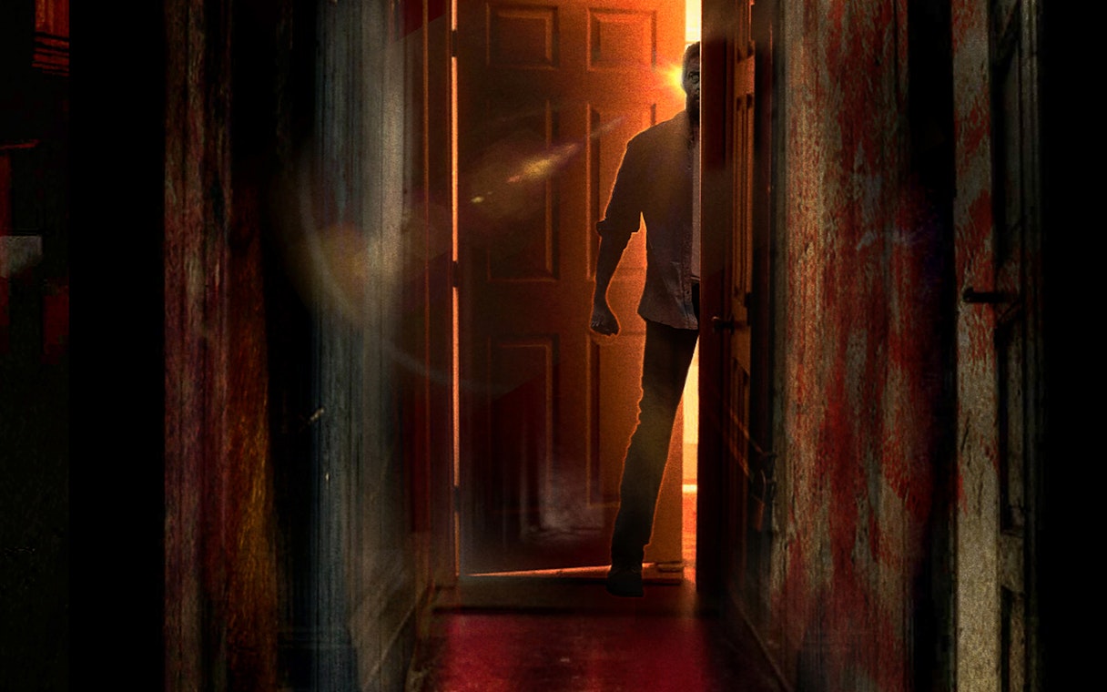 Person entering dimly lit escape room in Singapore with open door.