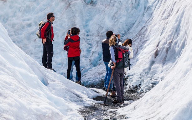 Group exploring Tasman Glacier on guided heli-hike tour.