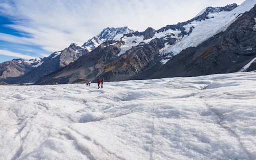 Hikers exploring Tasman Glacier during a guided heli-hike tour in New Zealand.