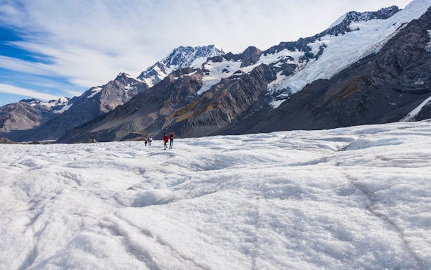 Hikers exploring Tasman Glacier during a guided heli-hike tour in New Zealand.