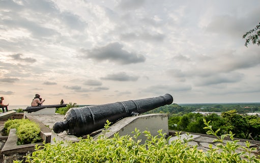 Historic cannon overlooking Kuala Lumpur skyline on Great KL City Tour.