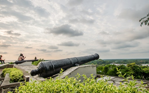 Historic cannon overlooking Kuala Lumpur skyline on Great KL City Tour.
