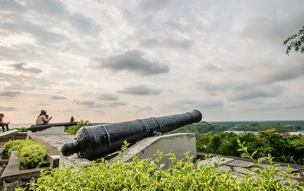 Historic cannon overlooking Kuala Lumpur skyline on Great KL City Tour.