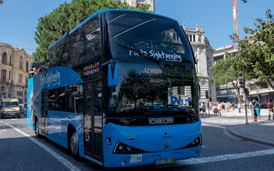 Porto sightseeing bus on city street during hop-on hop-off tour.