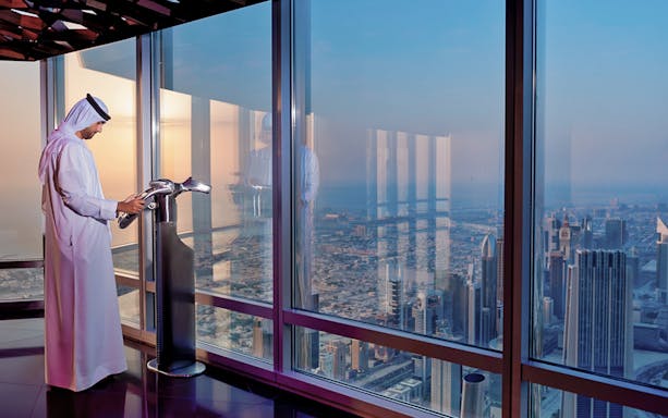 Viewing platform at Burj Khalifa with cityscape at sunset.