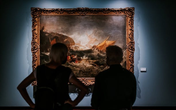 Visitors viewing a maritime painting at Calouste Gulbenkian Museum, Lisbon.
