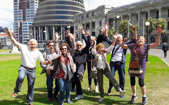 Group of tourists enjoying a guided tour in front of the Beehive, Wellington.
