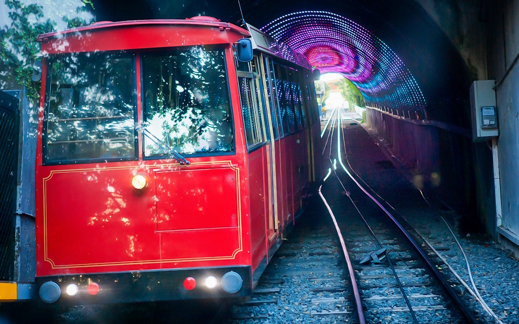 Red cable car exiting tunnel on Wellington highlights tour.
