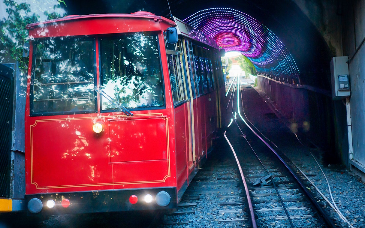 Red cable car exiting tunnel on Wellington highlights tour.