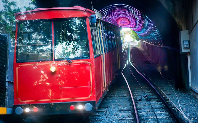 Red cable car exiting tunnel on Wellington highlights tour.