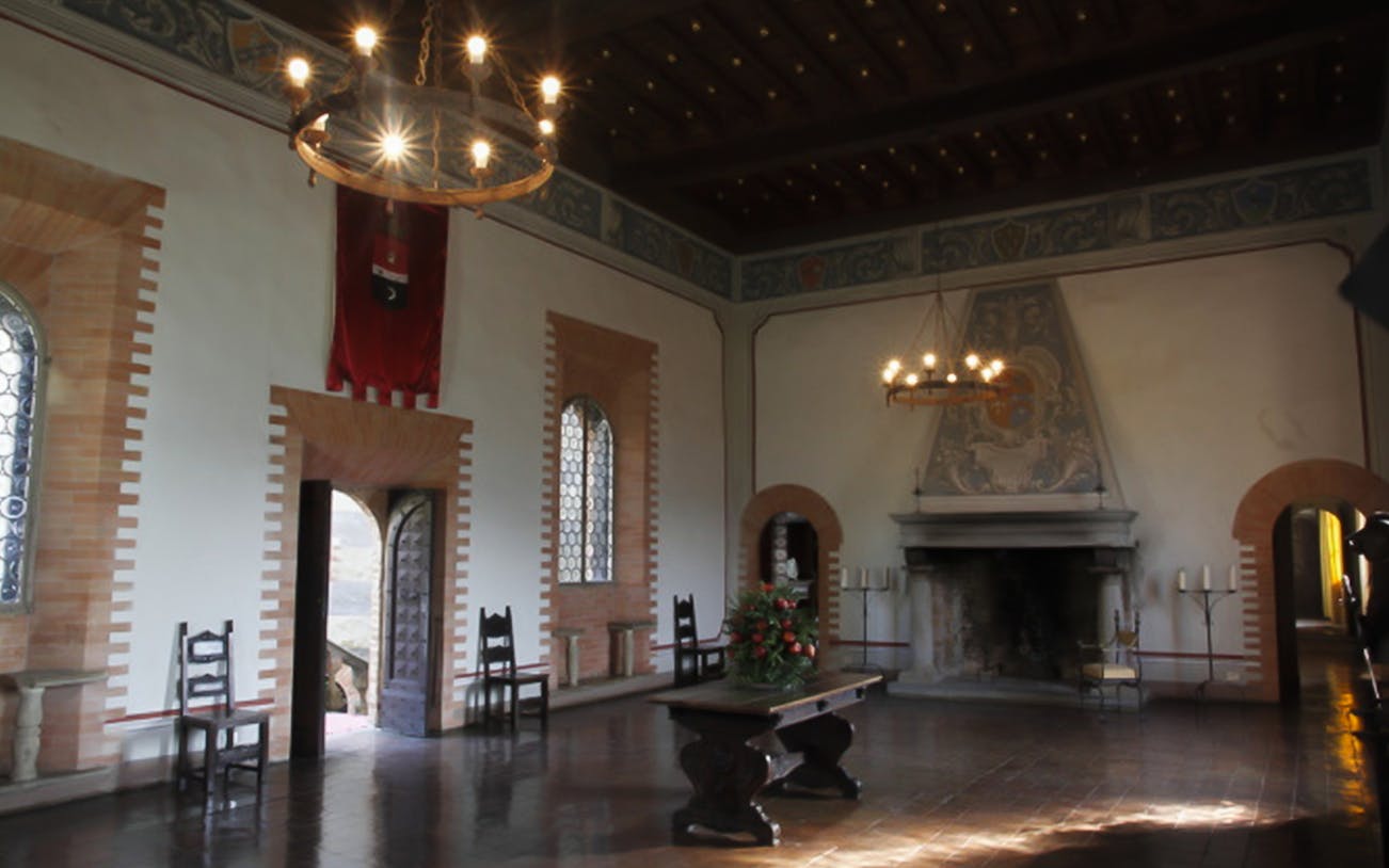 Gropparello Castle interior with medieval decor and dining setup.