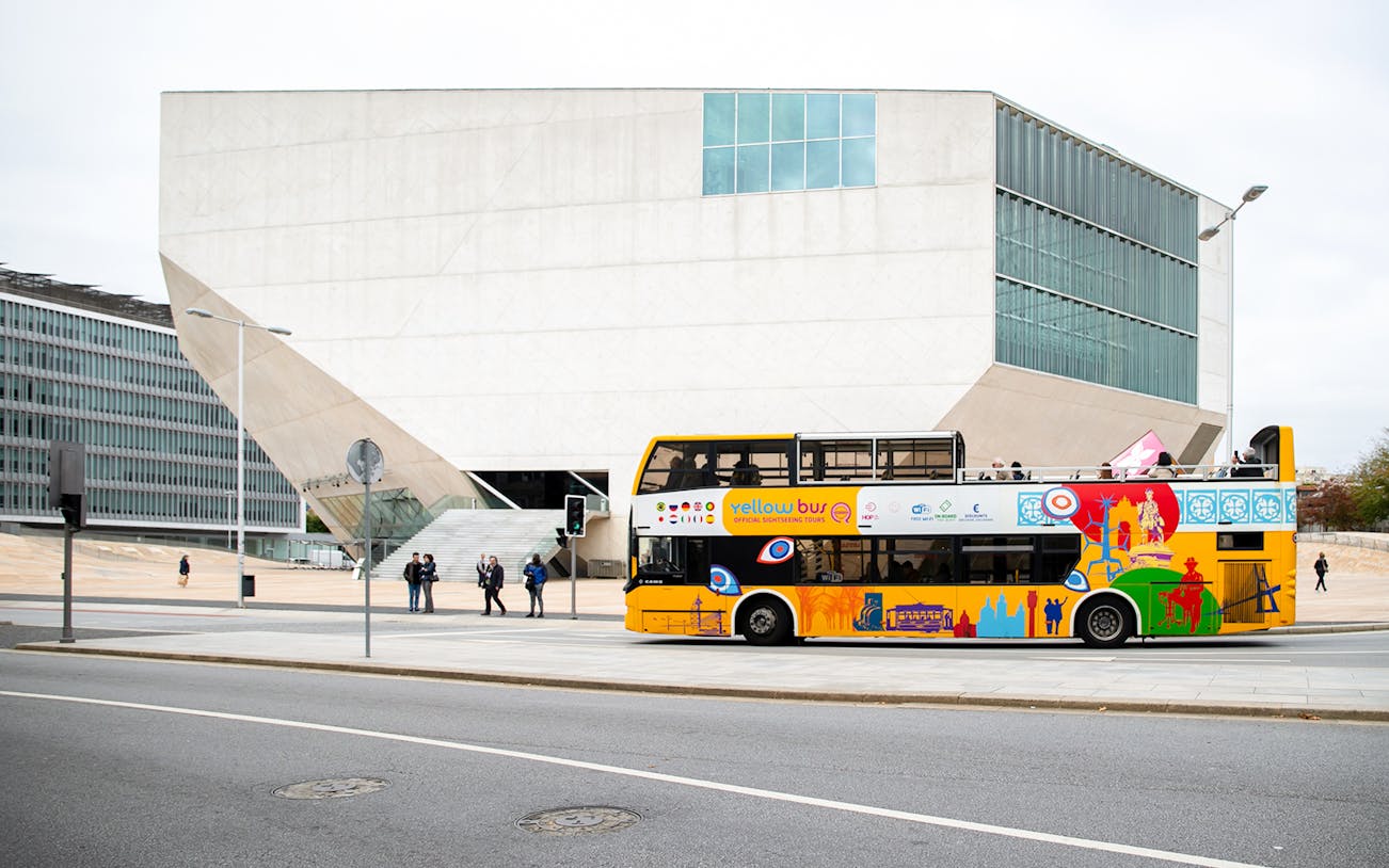 Porto vintage bus tour passing Casa da Música in Portugal.