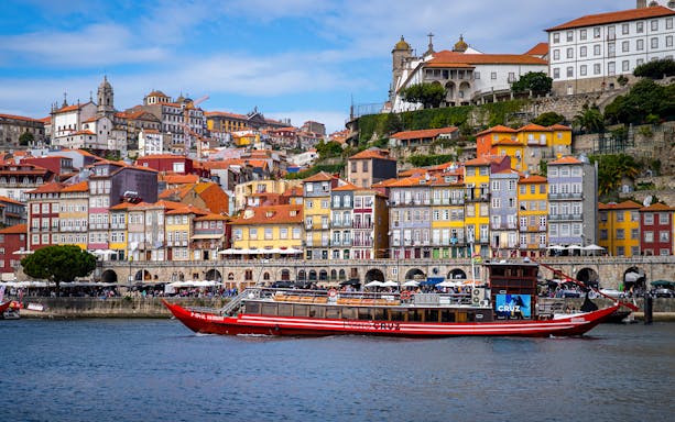 Porto's colorful Ribeira district with a vintage tour boat on the Douro River.