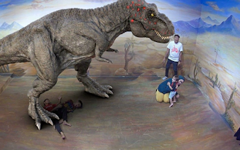 Visitors interacting with a 3D dinosaur illusion at Illusion 3D Art Museum Kuala Lumpur.