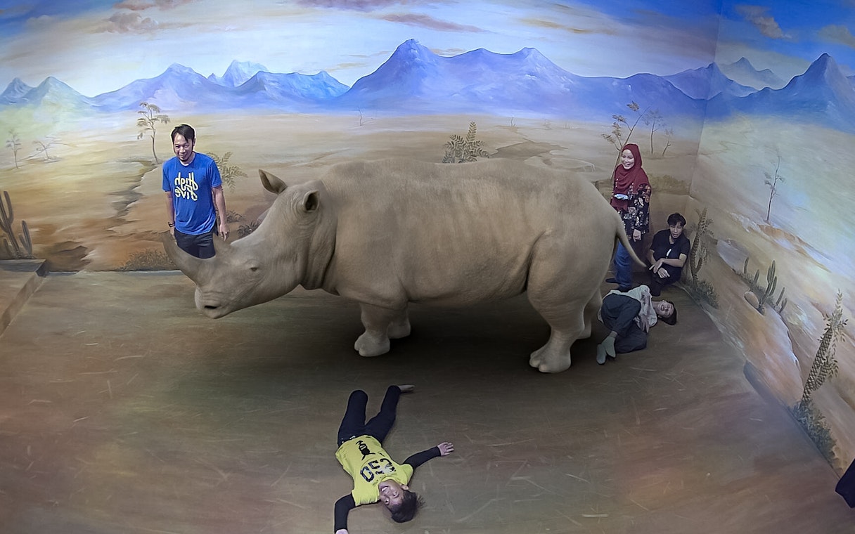 Visitors interacting with a 3D rhino illusion at Illusion 3D Art Museum Kuala Lumpur.