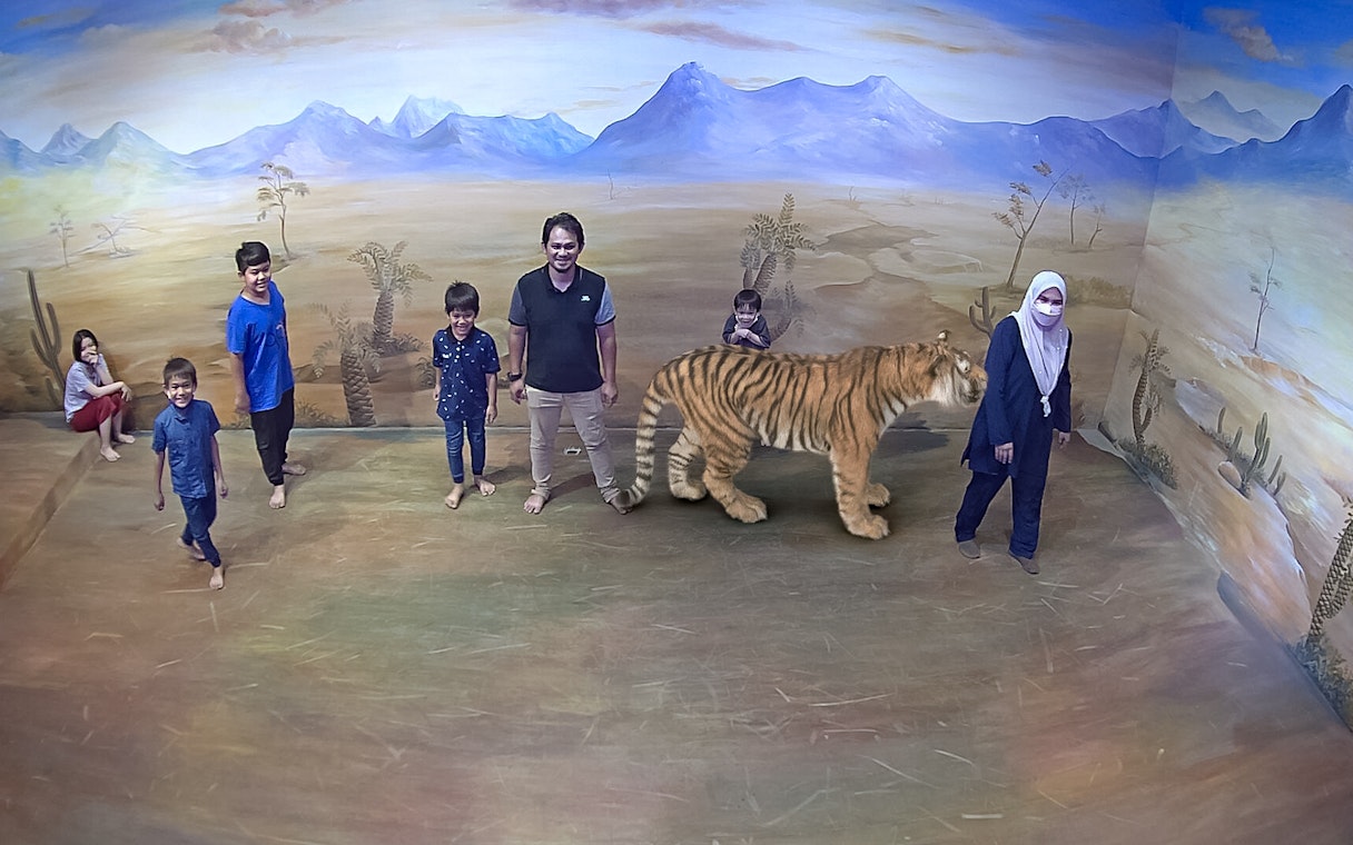 Visitors interacting with 3D tiger art at Illusion 3D Art Museum Kuala Lumpur.