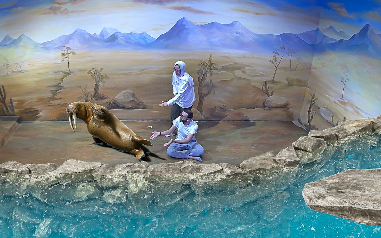 Visitors interacting with a 3D walrus art piece at Illusion 3D Art Museum Kuala Lumpur.
