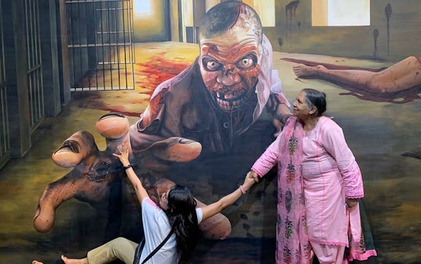 Visitors interacting with a 3D zombie mural at Illusion 3D Art Museum Melaka.