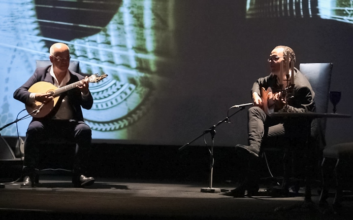 Musicians performing Fado in Chiado, Lisbon, with guitars on stage.