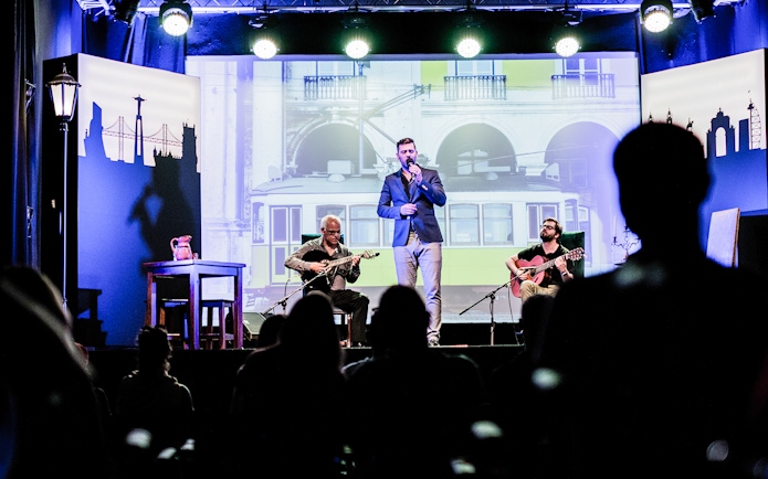 Fado performance in Chiado with musicians and singer on stage, Lisbon backdrop.