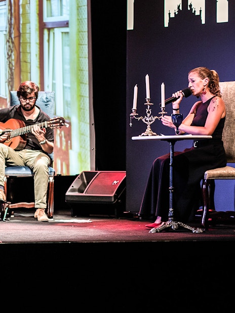 Musicians performing Fado in Chiado, Lisbon, with a backdrop of city buildings.
