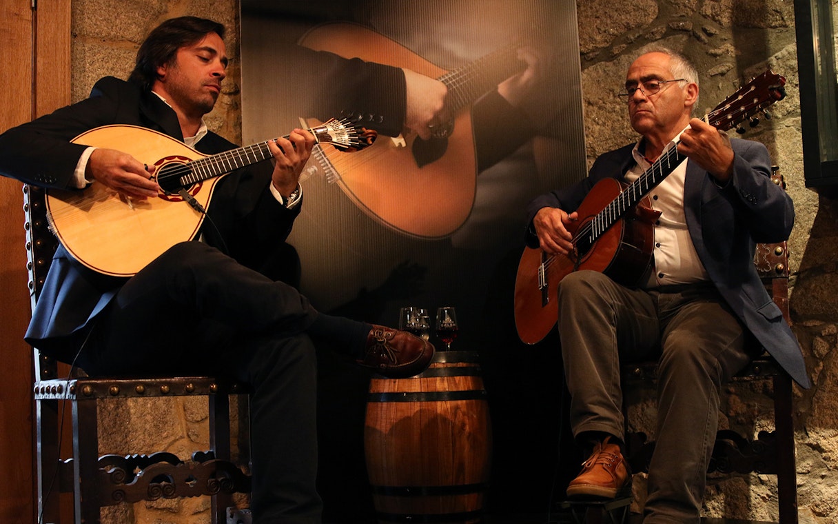 Musicians playing guitars at a Fado concert in a Port wine cellar.