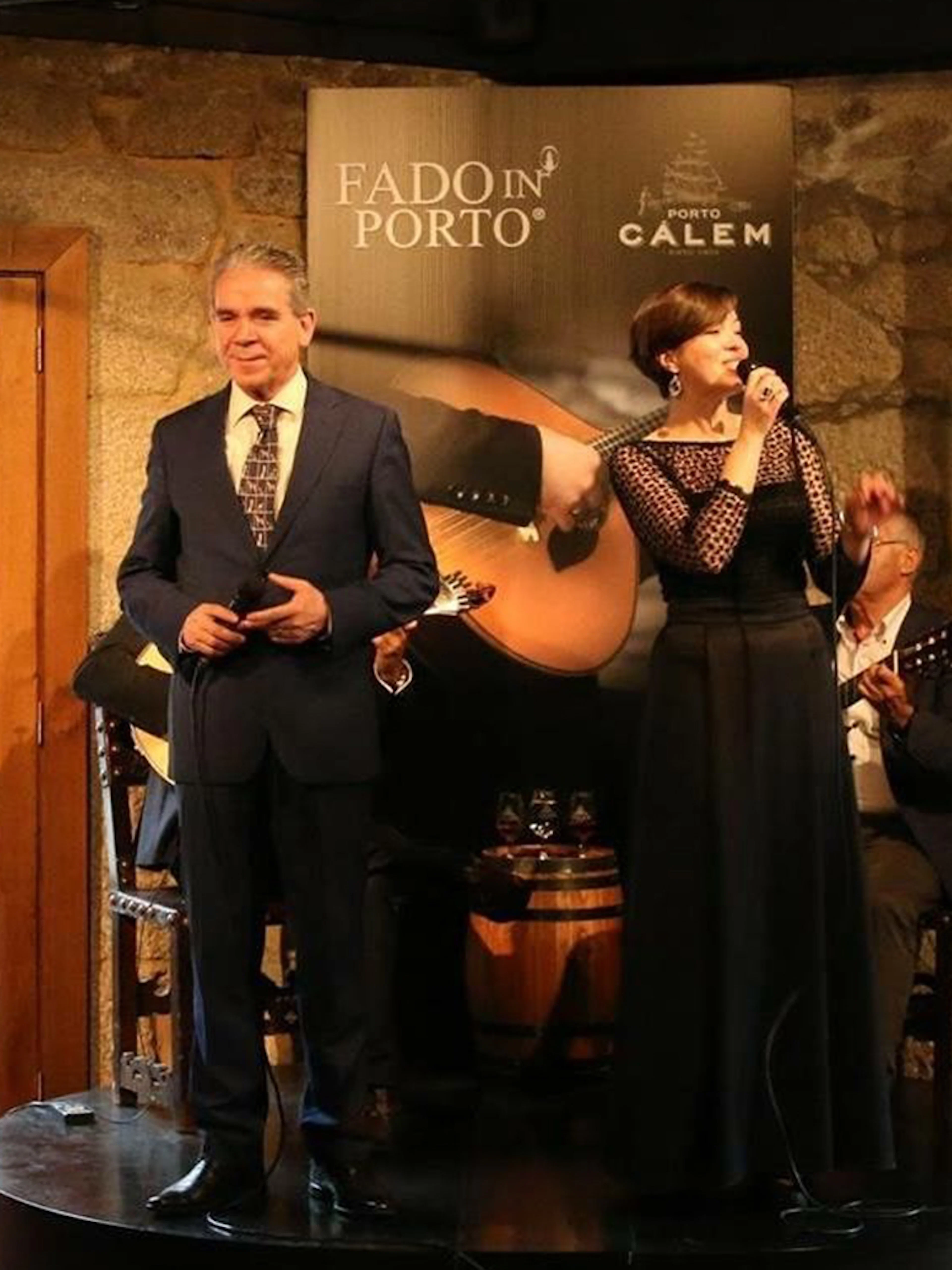 Fado singers performing in a Porto wine cellar with traditional Portuguese guitars.