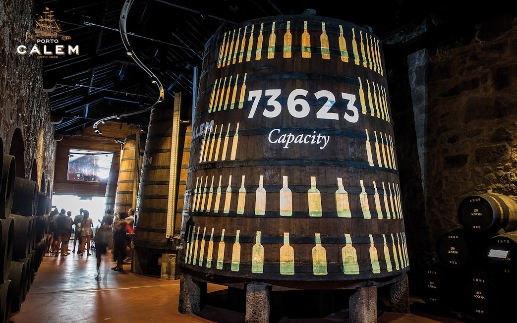 Porto wine cellar with large barrels, venue for Fado concert tickets.