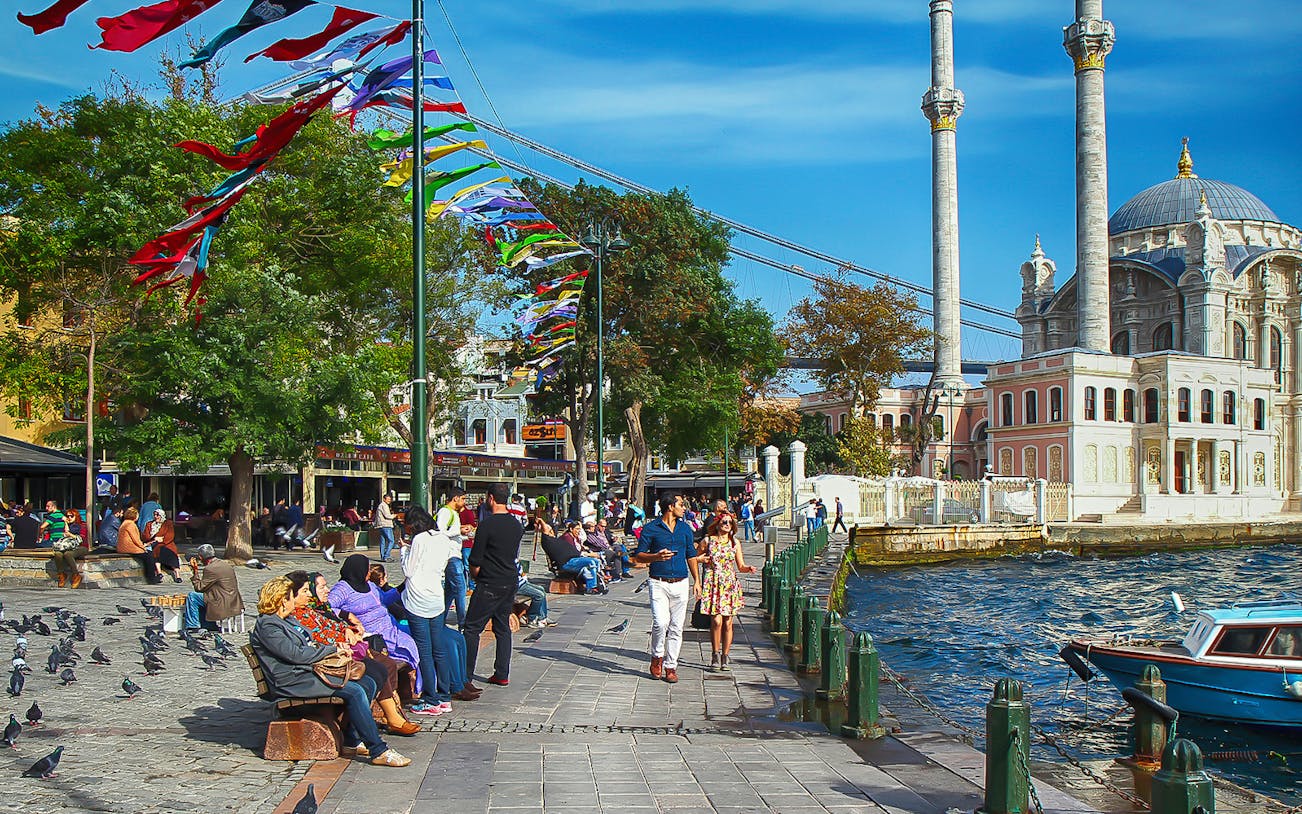 People walking along the Bosphorus near Ortaköy Mosque in Istanbul.