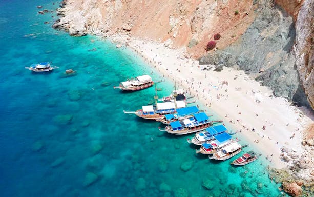 Boats anchored at Suluada Island beach with turquoise water, Antalya/Kemer.