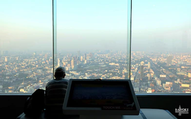 Baiyoke Sky Hotel observatory view of Bangkok cityscape through large windows.