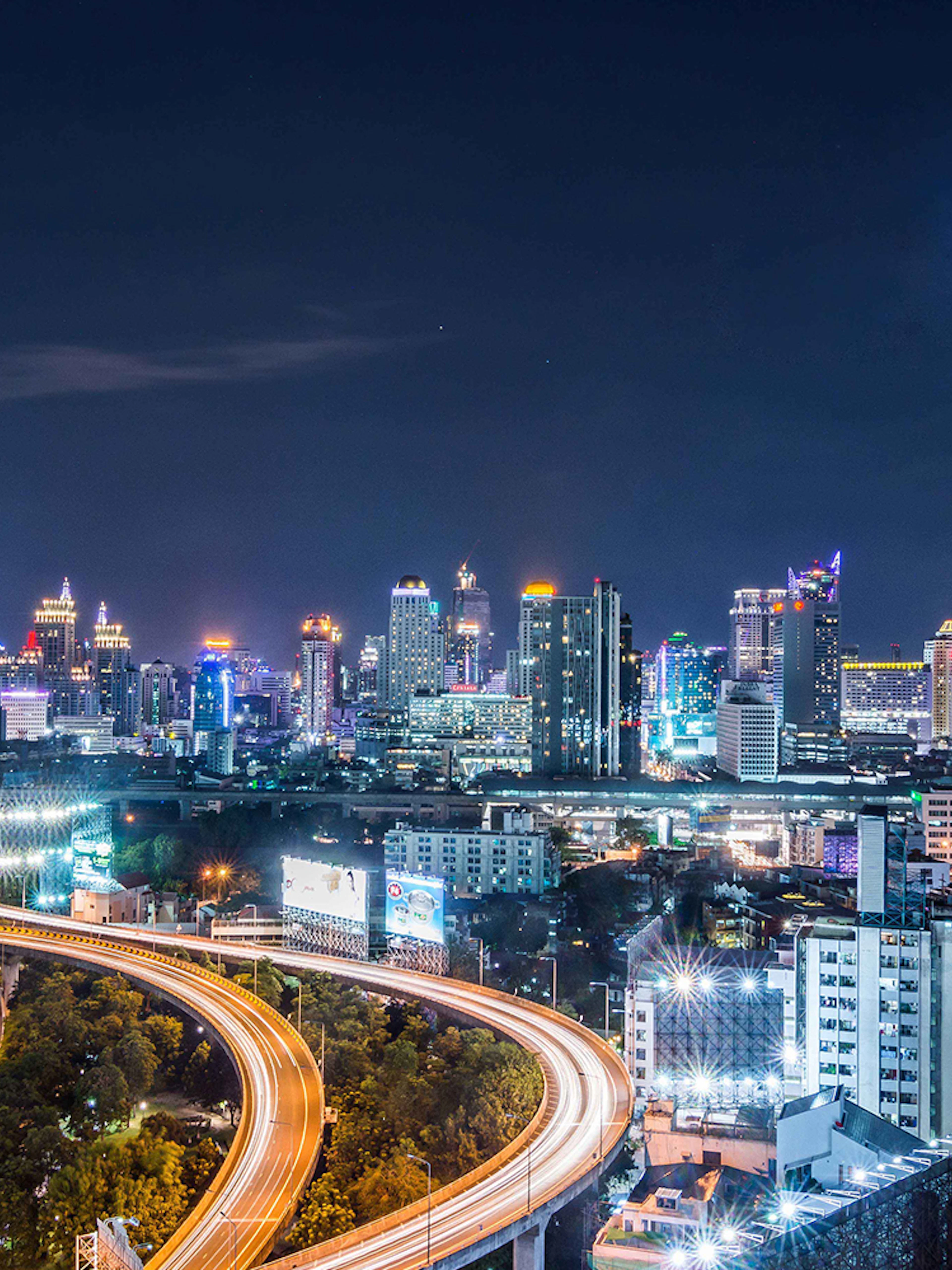 Bangkok skyline at night with Baiyoke Sky Hotel towering above city lights.